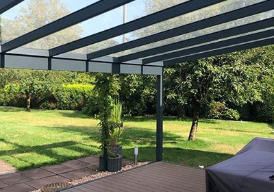 Anthrazitfarbenes Terrassendach mit Glaseindeckung, Blick von der Terrasse in den Garten