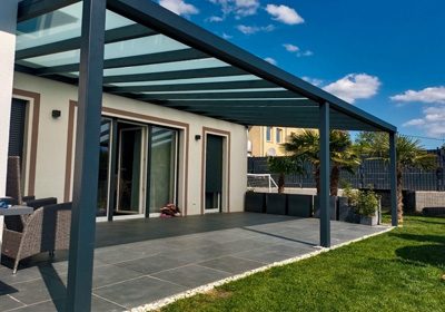 Freistehendes Aluminium-Terrassendach an einem Neubau bei Sonnenschein